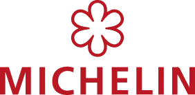 Logo de Michelin composé du nom de la marque en lettres rouges et d'une fleur à cinq pétales stylisée au-dessus